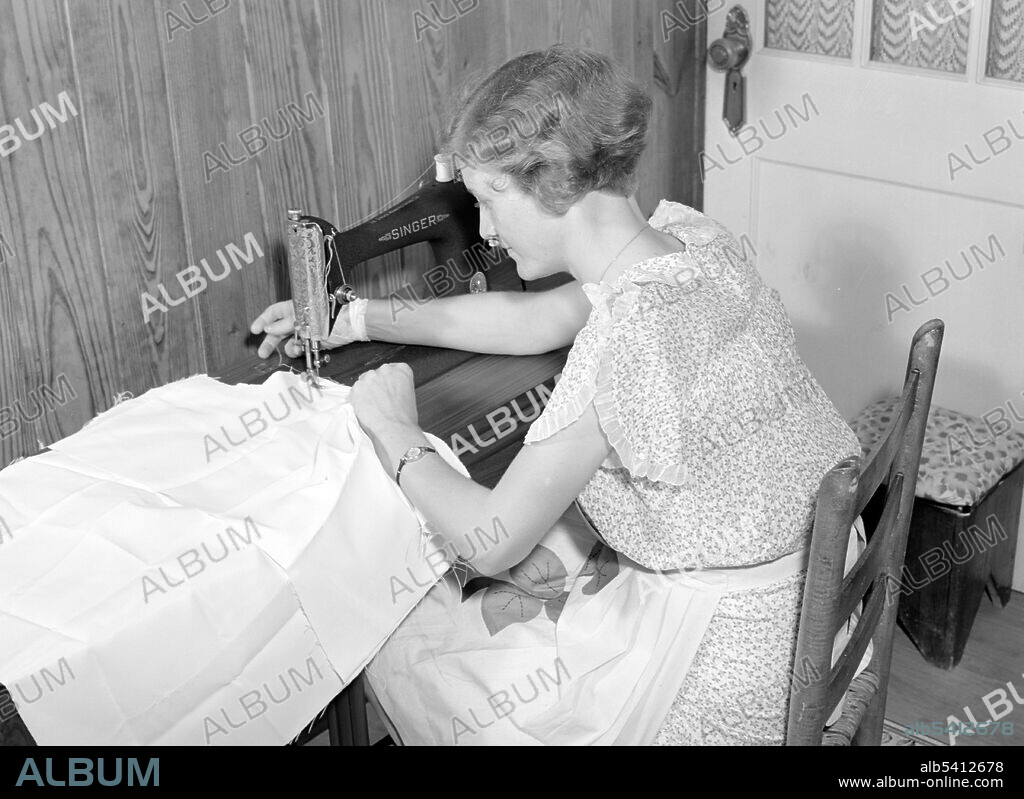 Mrs. Verden Lee sewing on her new sewing machine in her home. Transylvania Project, Louisiana. A sewing machine is a machine used to sew fabric and other materials together with thread. Home sewing machines are designed for one person to sew individual items while using a single stitch type. In a modern sewing machine the fabric easily glides in and out of the machine without the inconvenience of needles and thimbles and other such tools used in hand sewing, automating the process of stitching and saving time. Marion Post Wolcott, 1940 (cropped and cleaned).