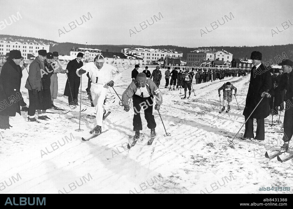 SOLLEFTEÅ 1934-02-23.. Världsmästerskapen i nordisk skidsport i Sollefteå 20-25 februari 1934.. Skidlöparna efter starten på stafettlöpningen 4 x 10 km. vid FIS-tävlingarna i Sollefteå. Här ses A. Karlsson (tv), Sverige, och S. Nurmela, Finland, i ledningen, och bakom dem Motz, Tyskland, och Bergendahl, Norge.. Foto: AB Text & Bilder / SVT / Kod: 5600. Mapp: I.F.S:-spelen i Sollefteå 1934: Stafett 4 x 10 km. d. 23 febr. I:37h. FIS - Fédération International de Ski Skidtävlingar Längdskidåkning Skidåkning.