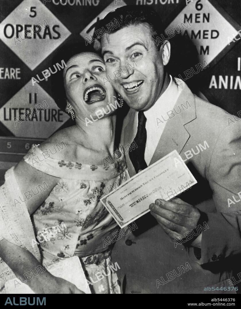 He-Quits A-Winner - Redmond O'Hanlon, New York City policeman, and his wife, Marguerite, mother of their five children, have good reason to be Jubilant tonight. O'Hanlon holds cashier's check for $16,000 in a television studio after winning that amount on his knowledge of Shakespeare on TV quiz show. He had dilemma of attempting another question on Shakespeare to double the amount. He elected instead to take the money, explaining a "father's conservatism" won out over a scholar's egotism. June 21, 1955. (Photo by AP Wirephoto).