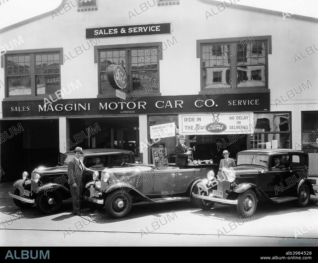 1932 Ford V8 in front of a car showroom, (c1932?). In 1932, Henry Ford introduced his last great personal engineering triumph, the cast-in-one-piece, V8 engine. Offered as an option to an improved 4-cylinder Model 'B' engine in this low priced car, this compact V8 power plant, with its down draft carburetor, enabled the 1932 Ford to outperform its competitors and was 20 years ahead of its time. The improved proportions and styling of the car reflected Edsel Ford's genius for design.