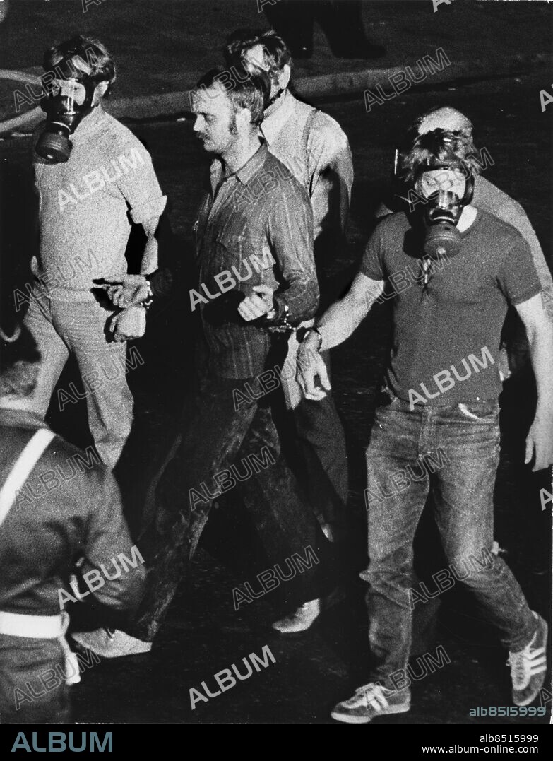 ARKIV 1973-08-29. Rånaren Jan-Erik Olsson förs ut efter det nära sex dagar långa Norrmalmstorgsdramat. Efter att ha tagit fyra anställda som gisslan kräver Olsson att få dit den kände bankrånaren Clark Olofsson, som också förs dit från fängelset efter ett regeringsbeslut. Media direktsänder och svenska folket följer spänt utvecklingen i bankvalvet på Kreditbanken på Norrmalmstorg i Stockholm. Till slut sänder polisen in gas och rånaren ger sig. Foto: Bertil Ericson / SCANPIX / Kod: 1002.