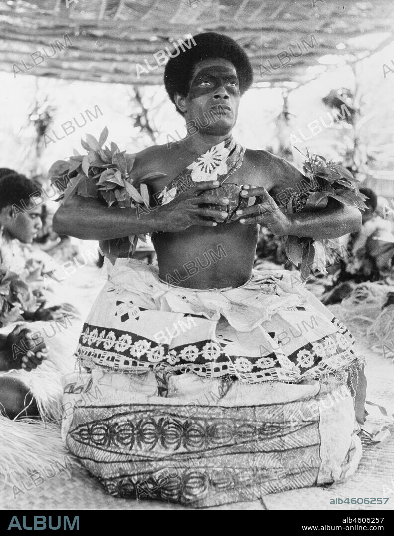 Fiji, Preparing to drink a kava infusionA Fijian man prepares to drink an infusion of water and powdered kava root (Piper methysticum) from a 'bilo' (half coconut shell) during a traditional 'sevusevu' welcoming ceremony. Naked from the waist up, he wears ceremonial costume including dramatic face paint and a tiered 'masi' (bark cloth) skirt. Caption reads: Presentation of the Yanqona cup, 1965. 2005/010/1/14/50.