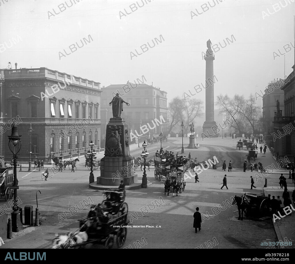 Waterloo Place, London, after 1881, looking south towards the Duke of York Column, on a misty winter's day. The equestrian statue of Field Marshal Napier (replaced in the 1920s by one of Edward VII) is immediately to the north and the Guards' Crimean Monument is also prominent. The Place is busy with horse drawn and pedestrian traffic.