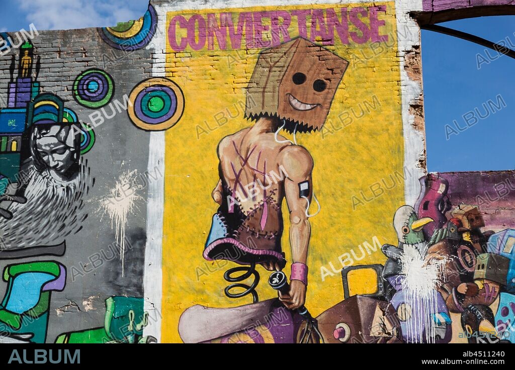 Ilustración estilo cómic de un cuerpo con cabeza de bolsa de papel con cara sobre fondo amarillo, graffiti mural, calle Venezuela, Poblenou, Distrito San Martin, Barcelona, en 2016.