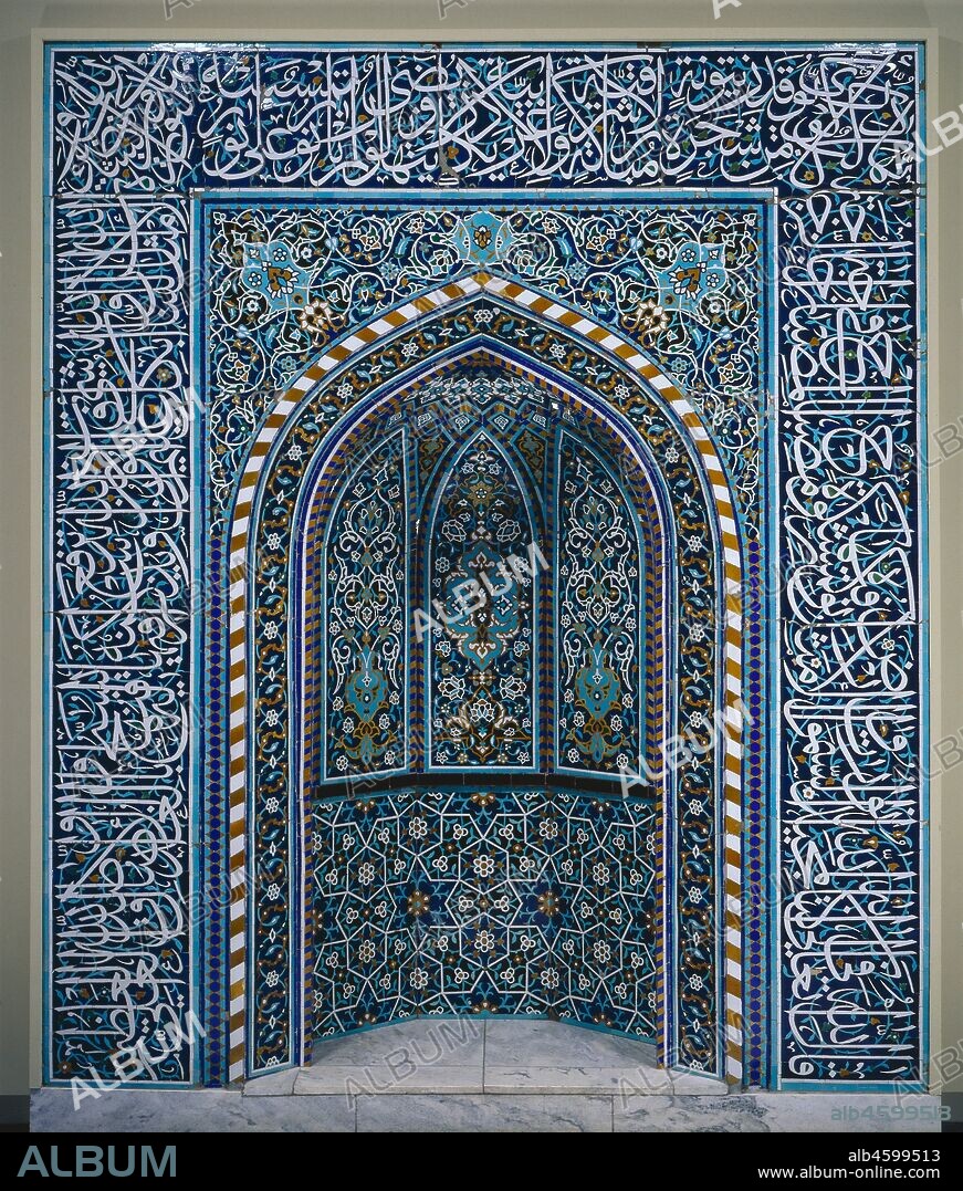 Prayer Niche (Mihrab), early 1600s. The prayer niche (mihrab in Arabic) is the focal point in the interior of a mosque. It is located in the qibla wall which is oriented toward Mecca, the holy city of Islam. Muslims face the qibla wall during prayer. This mihrab is an excellent example of different design elements-calligraphy, plants, and geometry-integrated into a beautiful harmonious whole. Graduated colours and sizes contribute to its success. The dominant white glaze presents the most important verses from the Qur?an written in elegant thuluth script which frames the niche. White glaze also outlines geometric patterns and arabesque vines. Less conspicuous turquoise glaze forms secondary designs such as curving vines behind the stunning calligraphy. Curved and straight lines are juxtaposed, enhanced with additional colours of mustard-yellow and aubergine on the deep blue ground. The design is formed with individual pieces of tile in the ceramic mosaic technique. Segments are cut according to the pattern from monochrome tiles with a chisel and their edges smoothed with a file. The pieces are then arranged face down according to a pattern and covered with plaster in manageable sections to install.