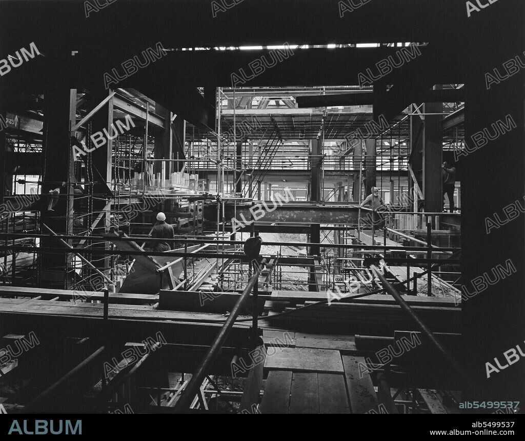 JOHN LAING PLC. Central London YMCA, Great Russell Street, Camden, London, 26/05/1972. A view looking through scaffolding and the steel frame of the podium and basements of the Central London YMCA building during its construction. It was announced in February 1971 that Laing had started work on a new building at Central London YMCA, to replace an existing building which had opened in the 1910s. The project comprised four residential towers between 6 and 12 storeys high, above a podium and basements. The basements and podium, which were built using reinforced concrete and structural steel, comprised Phase I of the project; the towers were built in Phase II. The building was completed in 1977.