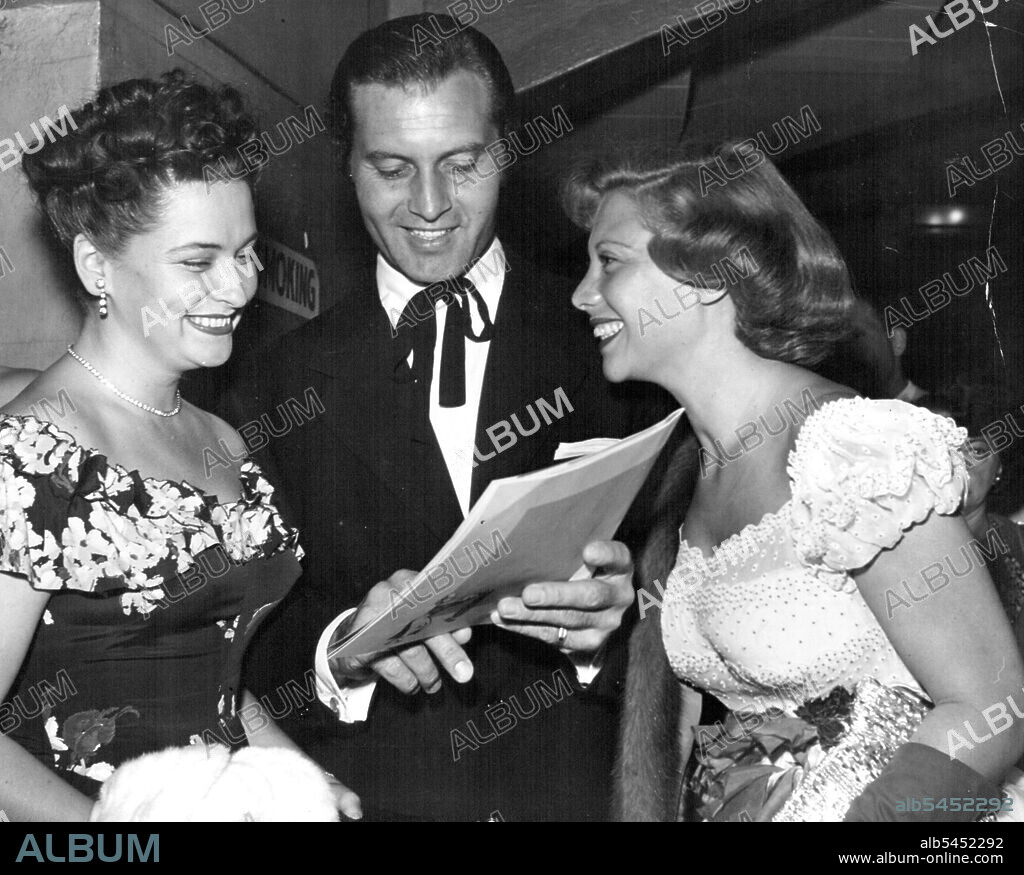 Mrs. John Raitl with George Montgomery and his wife, songstress Dinah Shore, at the opening in Los Angeles of a musical called Magdalena. Mrs. R's husband was the star. That tie must be an old Southern custom. October  27, 1948.