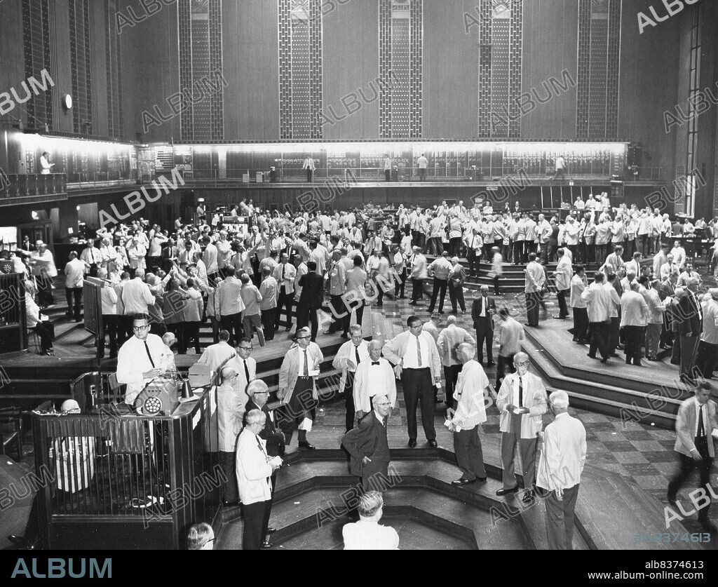 Trading floor of the Chicago Board of Trade, foreground shows oats pit, behind and to the left, wheat pit, at right, edge of corn pit and beyond, soybean pit. Chicago, IL, 1965.