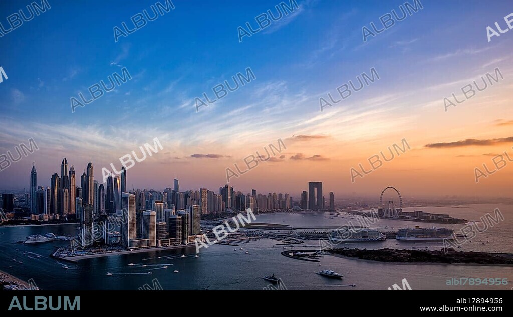 View from viewing platform The View At the Palm to skyline with Princess Tower, Elite Residence, Ferris wheel Ain Dubai, luxury yacht OPERA owned by Sheikh Mansour bin Zayed Al Nahyan from the ruling family of the Emirate of Dubai, anchored in front of EMAAR Beachfront, Logo, Evening atmosphere, Dubai Marina, Dubai, United Arab Emirates, VAR