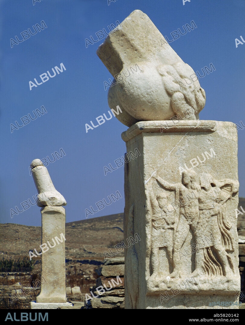 Dionysos sanctuary, Delos. Two monumental phalli with a relief showing Dionysos with Silenos and a Maenad. Inscription says the monuments were donated by Karystios, son of Asbelos. (around 300 BCE).
