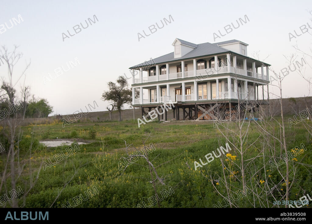 An elevated house along the Mississippi levee south of New Orleans in Plaquemines Parish, Louisiana. The area is prone to flooding from hurricanes.