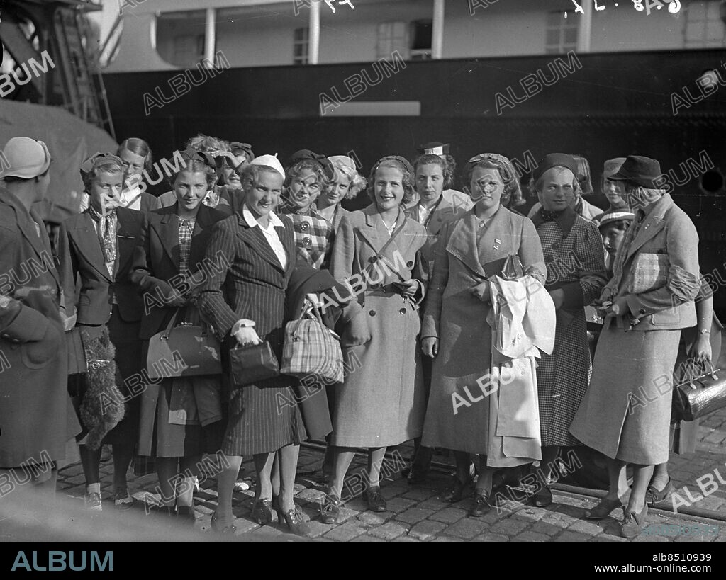 Göteborg - 1937-08-06 - En stor grupp välklädda kvinnor framför fartyg i hamnen - det är käcka svenska töser, allt enligt bildtexten, som varit i England i sommar. Nummer tre från höger är fröken Märtha Wildner från Norrköping - de kommer med ett fartyg tilhörande Svenska Lloyd - *** Local Caption *** GT Låda 1937-augusti-03. KAMERAREPORTAGE.