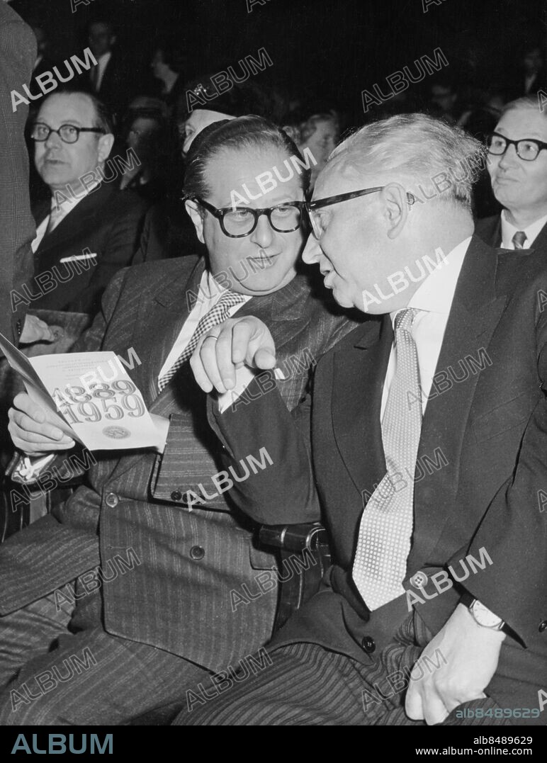 Orig. bildtext... Socialdemokratiska partiets 70-årsfirande i Konserthuset på söndagen samlade många utländska gäster. Vice utrikesminister i Österrike Bruno Kreisky studerar här programmet tillsammans med Erich Ollenhauer. Anm. B Kreisky, 1911-90, österrikisk politiker (socialdemokrat), förbundskansler 1970-83. E Ollenhauer, 1901-1963, västtysk politiker (SPD). Profiler Socialdemokratiska arbetarepartiet Samtal CD341 persons: ERICH OLLENHAUER;BRUNO KREISKY sites: ÖSTERRIKE*;STOCKHOLM;SVERIGE.