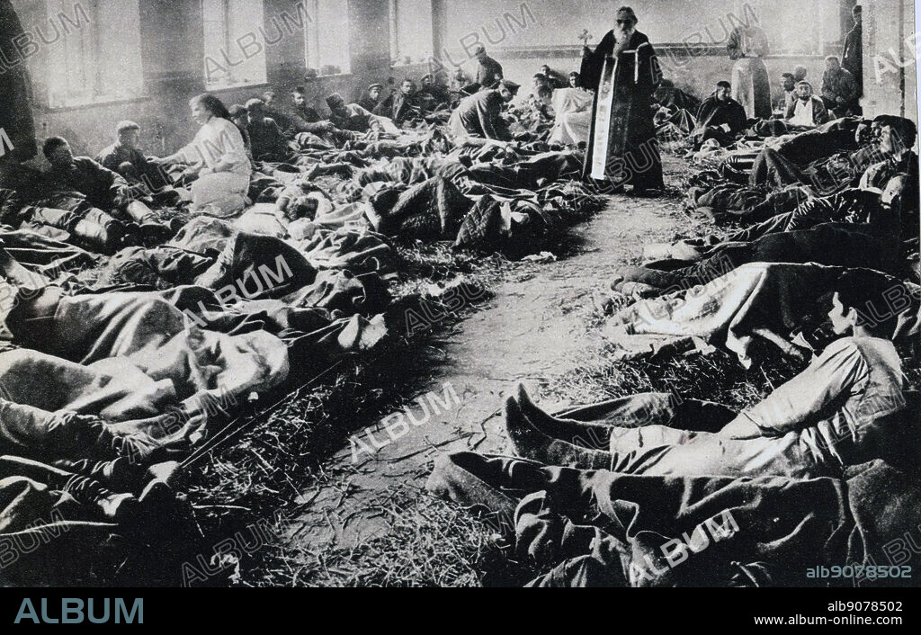 World War I: Orthodox priest in a Russian military hospital ward.