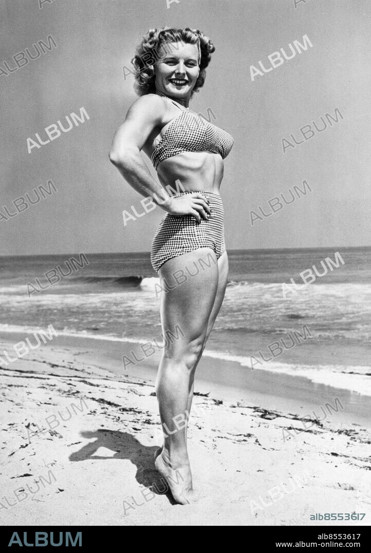Orig. bildtext... New York, N.Y.... (Photo at left) Abbye (Pudgy) Stockton, 30, of Santa Monica, California, was picked as the Physical Culture Venus and awarded a $1000 prize in this year's Physical Culture Magazine Contest. Abbye is 5ft.1inches tall and weighs 116 pounds. She has a 36 and 7/8 inch bust, 23 and 1/2/ inch waist and 34 inch hips. Anm. Se även BCB649. A Stockton, f Abbye Eville, 1917-2006, amerikansk kroppsbyggare; pionjär inom kvinnlig bodybuilding. Bildserier Fotoreportage Biceps Styrka Sandstränder Tvådelat Baddräkter Bikini Vågor På tå Muskler Händerna i sidan Balans CD670 persons: ABBYE (PUDGY) STOCKTON sites: NEW YORK;USA.
