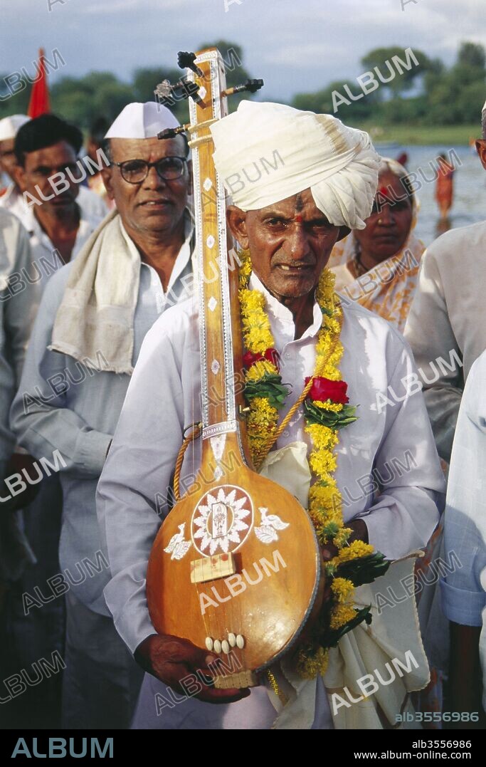 old pilgrim playing ek tara, ashadhi ekadashi fair, pandherpur, maharashtra, india.