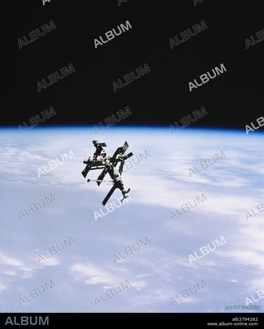 The Russian space station Mir, ('peace'), in orbit. Mir was launched February 1986. The space station orginally consisted of a core module and docking facilities. A variety of science modules were then adding, increasing Mir's mass from its original 21 tonnes to over 100 tonnes. This image was taken from the shuttle Atlantis during mission STS-71, when Atlantis docked with Mir for a week of joint experiments, (June 27, 1995-July 7, 1995).