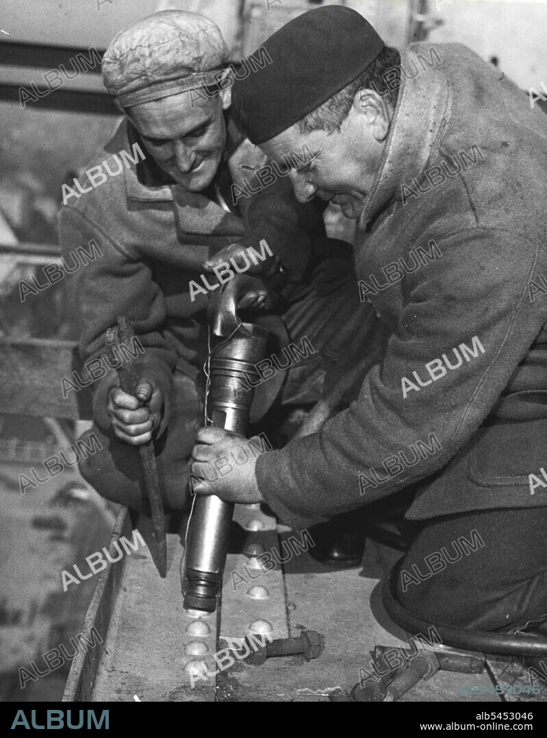 RivetersHeavy clothing is worn by Clem Broomfield (iron worker) & Jerry Maloney (boilermaker) as they work in the breeze high above the water at Garden Island. June 15, 1950.