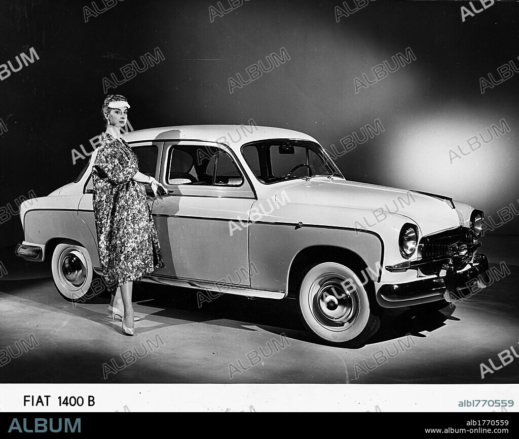 A model next to a Fiat 1400 B. An Italian model next to a Fiat 1400 B car presented at the 38th International Auto Show. Turin, April 1956.