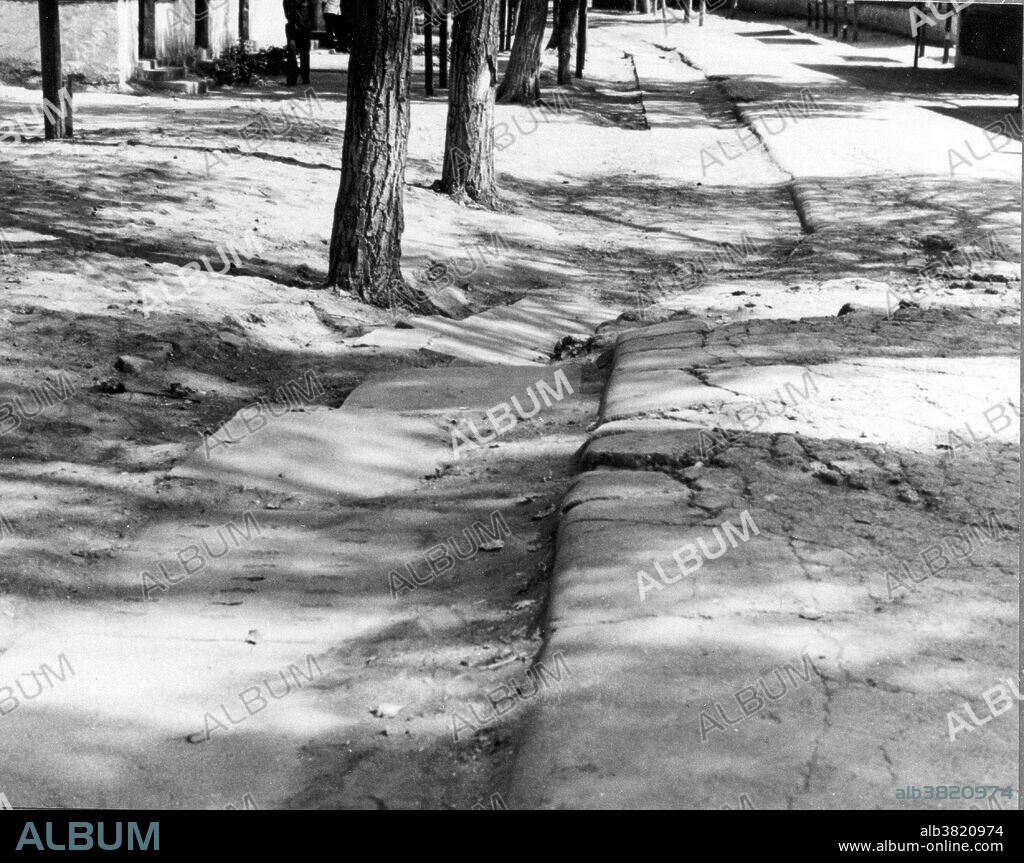 Tangshan, China, Earthquake July 27 UTC (local time July 28), 1976.  Road at Tangshan No. 10 Middle School offset by displacement on the fault. This earthquake occurred in the northeastern part of China, near the coast. The epicenter was centered about 140 kilometers southeast of Beijing, in the vicinity of Tangshan. The first earthquake, magnitude 7.5, was followed by a major aftershock 15 hours later. According to official sources, the two earthquakes killed 242,769 people, although some estimates of the death toll are as high as 655,000. Over 799,000 people were injured. Aftershocks in the 5.0-5.5 range continued after the main shock. Damage extended as far as Beijing.