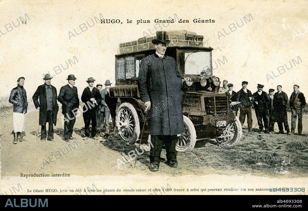 'Hugo, le plus grand des geants'. Les freres Hugo presentent un cas de gigantisme unique au monde. Ils sont nes a St Martin Vesubie dans une petite maison isolee sur la montagne. Baptiste l'aine mesure 2.30 et il pese 430 livres. Antoine son frere est ne en 1889, il mesure 2.25 et pese 300 livres, sa taille s'accroit actuellement de 10 centimetres par an. D'apres la faculte de medecine, Antoine Hugo grandira encore plusieurs annees. Les freres Hugo detiennent le record de tous les geants et offrent 1000 francs a leur rival. Carte postale vers 1910. Credit : Jean Vigne/KHARBINE-TAPABOR.