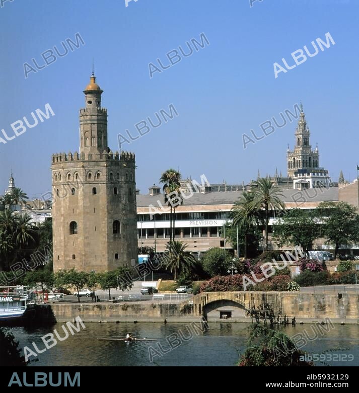 Sevilla, Guadalquivir und >Torre del Oro< (>Goldener Turm<, erbaut 1220 unter maurischer Herrschaft, Abschlußturm erbaut 1760). Der Turm diente als Wacht- und Leuchtturm des Hafens von Sevilla. Hinten rechts der Turm >La Giralda< (12./16. Jh.). Spanien, Andalusien. Sevilla, Andalusien, Spanien.