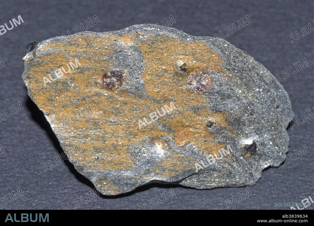 Schist is a metamorphic rock - rocks that have developed into new rocks due to changes in condition in the earth's crust. Garnet is a mineral.