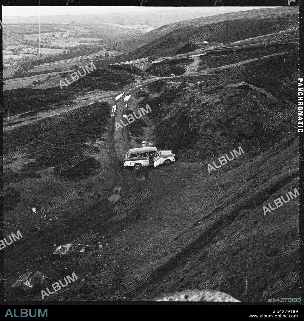 EILEEN DESTE. Hollins Mine, Rosedale Chimney Bank, Rosedale, Ryedale, North Yorkshire, 1967. A view looking down towards a car parked beside spoil heaps at Hollins Ironstone Mine. In 1853 magnetite ore, a high grade iron ore, was discovered just north east of Hollins Farm, Rosedale. Hollins was the first of a number of mines to be established around Rosedale and was worked intensively from 1859 by the Rosedale Mining Company. The mine is now a Scheduled Monument.