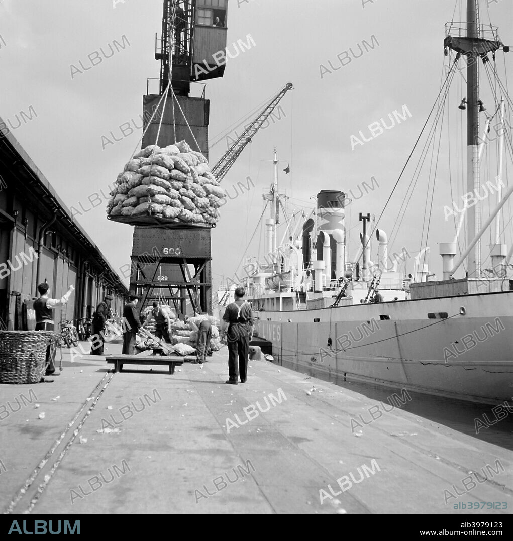 North Quay, West India Docks, London, c1945-c1965. Sacks of cargo being loaded onto a vessel at the North Quay, West India Docks, (now West India Quay). These docks, originally built between 1799 and 1806, declined after the advent of containerisation and have since been redeveloped.