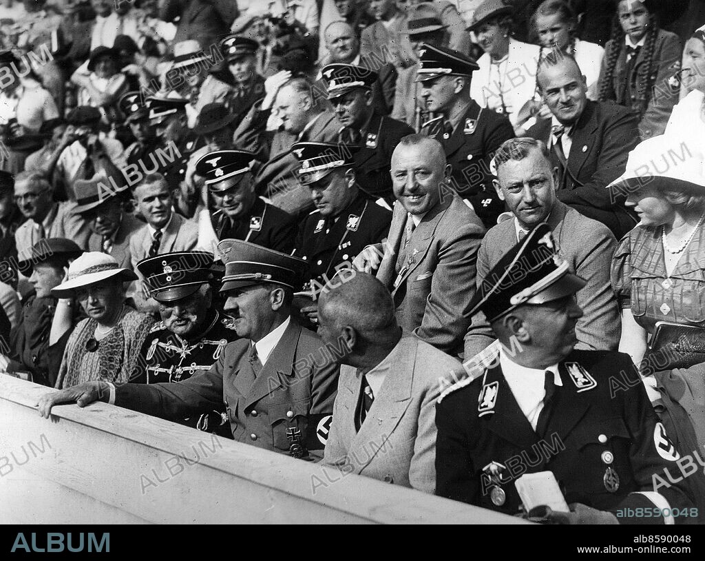 TYSKLAND BERLIN 1936-08-15.. Führern besöker simtävlingar under olympiska sommarspelen i Berlin 1936. Från höger ses, i första raden, Julius Schaub, SS-Obergruppenführer, Wilhelm Frick, tysk inrikesminister, Adolf Hitler, tysk rikskansler och führer, samt August von Mackensen, generalfältmarskalk. I andra raden ses Viktor Lutze, tysk militär, Hans Pfundtner, statssekreterare, och Walther Darré, SS-Obergruppenführer och tysk jordbruksminister. Bakom Lutze ses Hans Frank, tysk riksminister.. Foto: AB Text & Bilder / SVT / Kod: 5600. Tysk originalbildtext.. Mapp: Sommarolympiaden 1936 Simstadion I 263n.