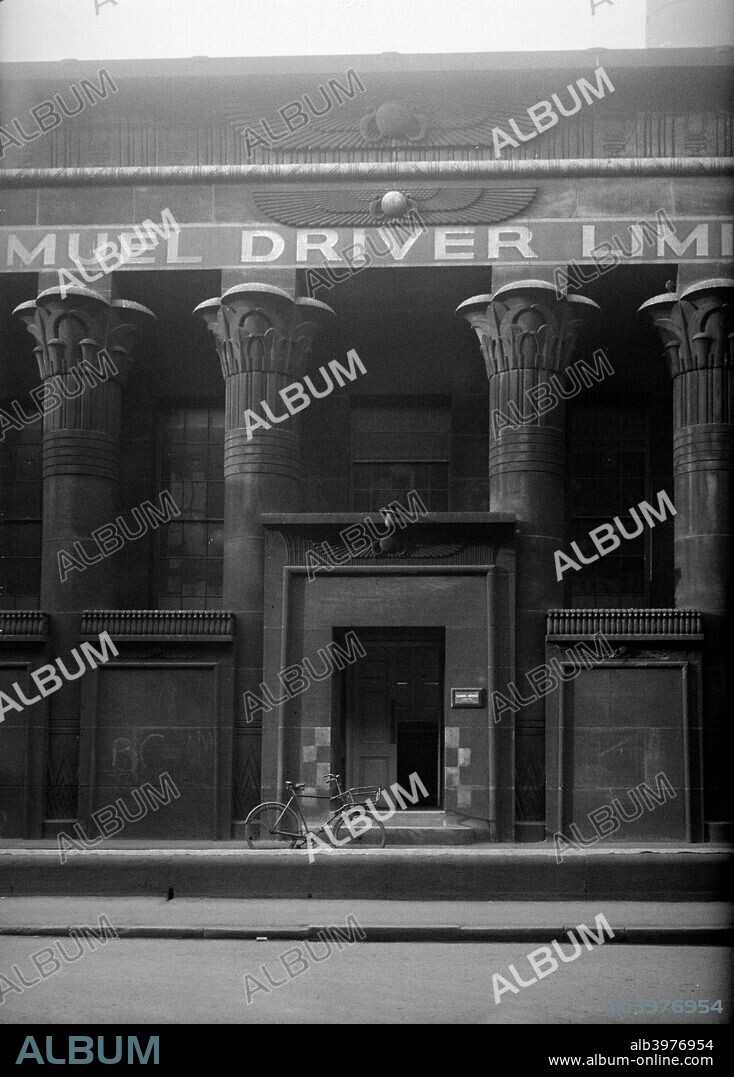 Marshall Mills, Leeds, West Yorkshire. Factory entrance in heavy Egyptian revival style. The facade features an arcade of lotus columns, and is blackened by soot; a bicycle is parked at the entrance. The mills were built in 1838-40 by Ignatius Bonomi.