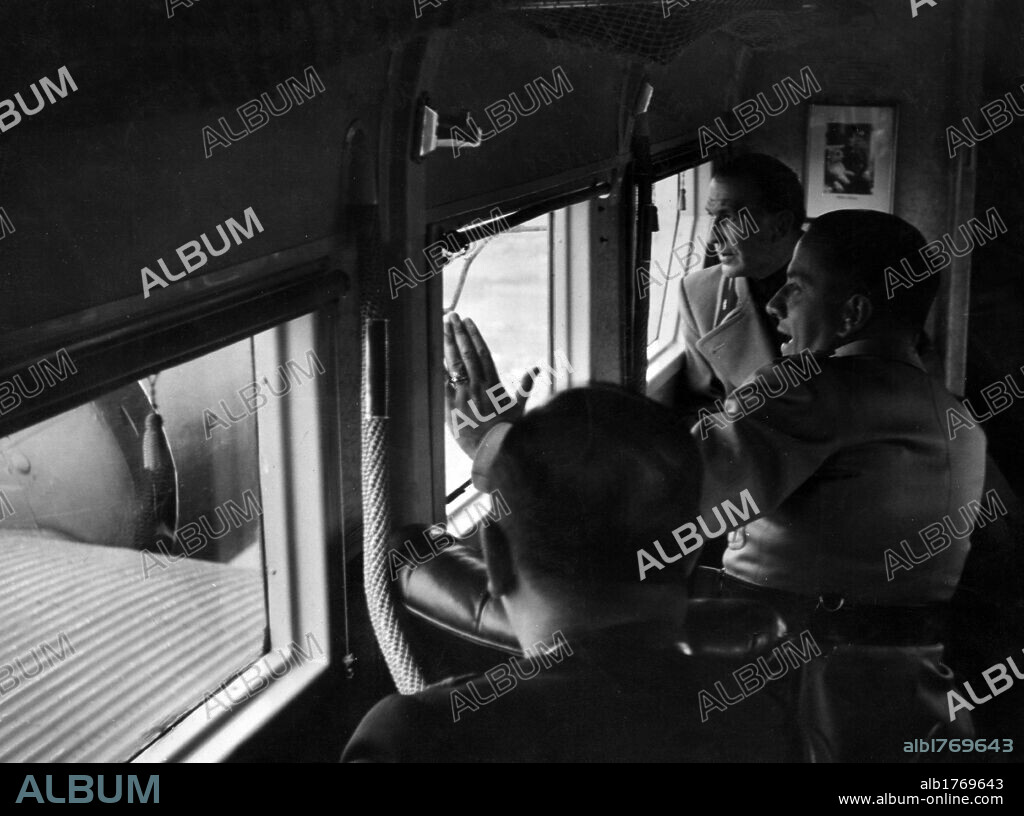 Dino Alfieri, Galeazzo Ciano and Giuseppe Teucci on a plane. The Italian ambassador to Berlin Dino Alfieri, the Foreign Minister Count Galeazzo Ciano and the aeronatical attache Colonel Giuseppe Teucci at the window of the plane that will take them to the southern front. August 1941.