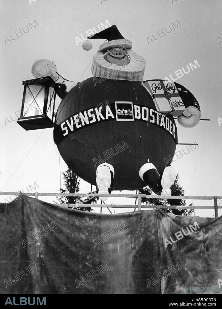 Stockholm 1963-12-17. Stockholms största tomte finns på taket till det nya parkeringshuset i Vällingby (som inte är klart än). Den är 10,5 meter hög och 7,5 meter bred och på kvällarna är den belyst av strålkastare. Ansikte och stövlar är av plast och Svenska Bostäder har satt upp honom för att öka julstämningen i Vällingby centrum...". Foto: Expressen / TT / Kod: 192. ** AFTONBLADET OUT **.