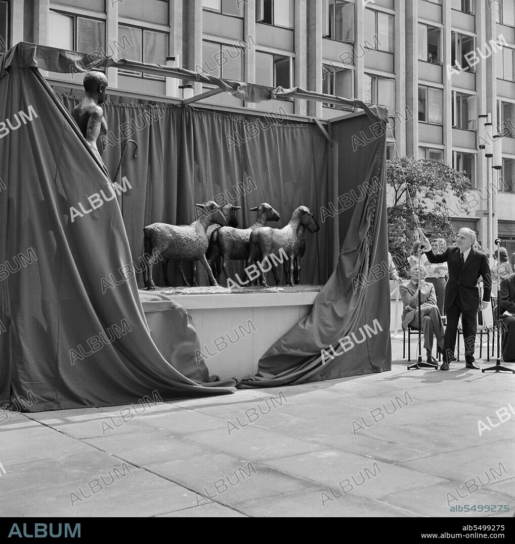 DAME ELISABETH JEAN FRINK. Paternoster Square, City of London, 30/07/1975. Violinist Yehudi Menuhin unveiling a bronze sculpture of a shepherd and his sheep by Elisabeth Frink at the Paternoster development. Work on the Paternoster development in the 1960's was carried out in a joint venture by John Laing Construction Limited, Trollope and Colls Limited, and George Wimpey and Company Limited. The development consisted of a series of office blocks, a shopping precinct, an extensive piazza and a three-level car park. In July 1975, a bronze statue of a shepherd and his sheep, sculpted by Elisabeth Frink, was unveiled at the Paternoster development by the world famous violinist Yehudi Menuhin. The sculpture was commissioned by Paternoster Development as their contribution to European Architectural Heritage Year. Among those present at the ceremony were Sir Kirby Laing and Geoffrey Anderson, then managing director of the Development company.