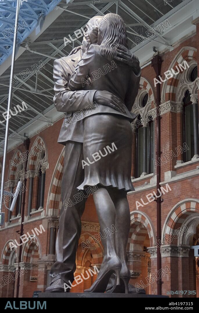 Meeting; Place; 30; foot; high; 20; tonne; bronze; statue; couple; embraciing; Paul Day; representation; traditional; under; clock; railway; station; St Pancras; International; Train; Station; London; NW1; England; inside; interior; Victorian; renovated; vertical; art.