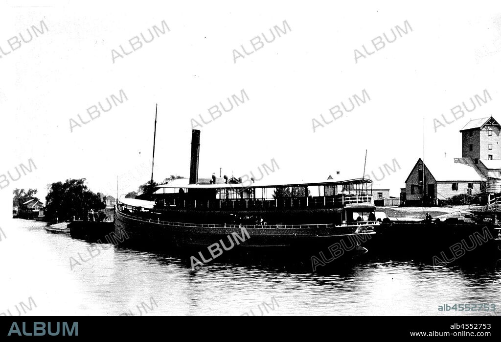 Negative - SS Gippsland at the Mitchell River Wharf, Bairnsdale, Victoria, circa 1910, The SS Gippsland tied up at the Mitchell River Wharf, Bairnsdale. There is a butter factory in the background. The screw steamer 'Gippsland' was a timber-hulled passenger ferry built by Peter Tierney, at Paynesville, for J.C. Dahlsen & Co., of Bairnsdale, in 1908. It was the largest and fastest steamboat to operate on the Gippsland Lakes with a top speed of 14 knots.