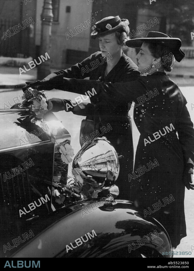 The Duchess of Kent Decorates Her Car -- The Duchess of Kent, who toured centres today which were selling Alexandra roses, decorated her car, before leaving home this morning. June 21, 1943. (Photo by Fox Photos).