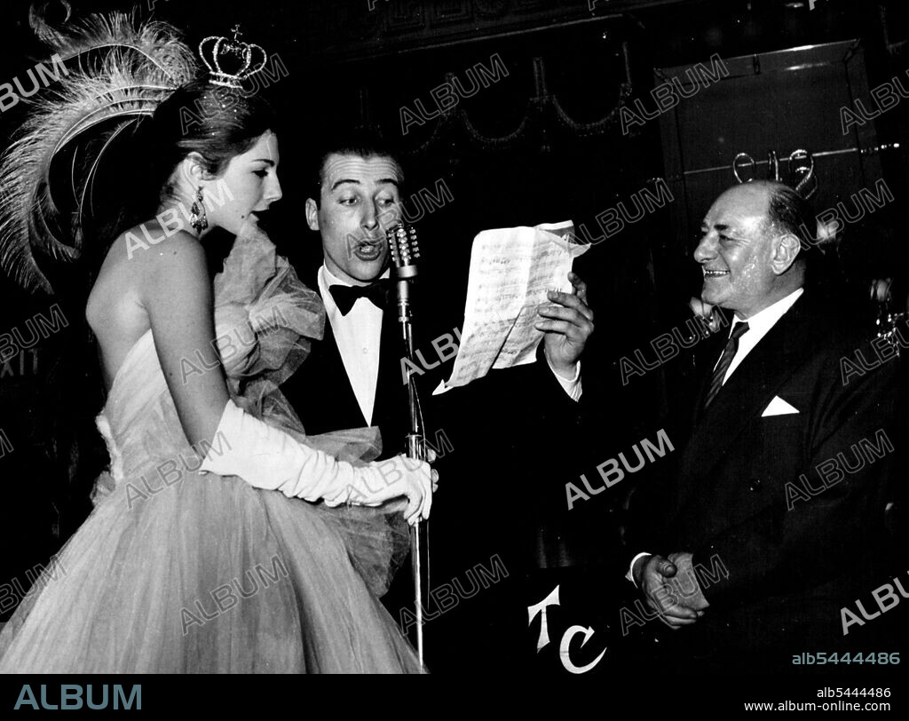 Lord "Porchie" Porchester sings in French to Fiona Campbell-Walter, who won the prize for the cleverest headdress. Bud Flanagan looks on in a benign way. Lord Porchester (Porchie) sings in French to society model Fiona Campbell-Walter (Miss Park Lane), who won the prize for the cleverest headdress. March 13, 1953. (Photo by Society General Press Agency).