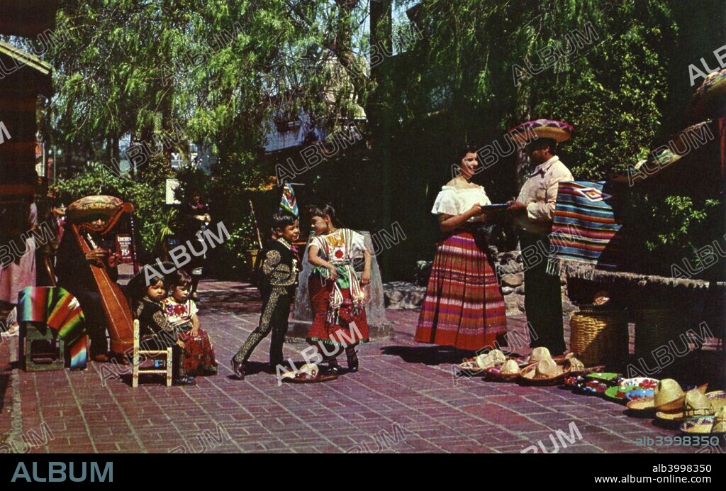 Olvera Street, Los Angeles, California, USA, 1953. Vintage postcard showing young Mexican dancers and vendors wearing traditional costumes on Olvera Street. Popular with tourists, Olvera Street is a recreation of old Mexico. A Mexican market has been held there since 1930.