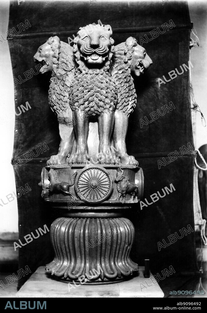 Asoka pillar with three lion heads showing - the famous original sandstone sculpted Lion Capital of Ashoka preserved at Sarnath Museum and originally erected around 250 BCE atop an Ashoka Pillar at Sarnath. The angle from which this picture has been taken, minus the inverted bell-shaped lotus flower, has been adopted as the National Emblem of India showing the Horse on the left and the Bull on the right of the Ashoka Chakra in the circular base on which the four Indian lions are standing back to back. On the far side there is an Elephant and a Lion instead. The wheel "Ashoka Chakra" from its base has been placed onto the centre of the National Flag of India.. ©TopFoto.
