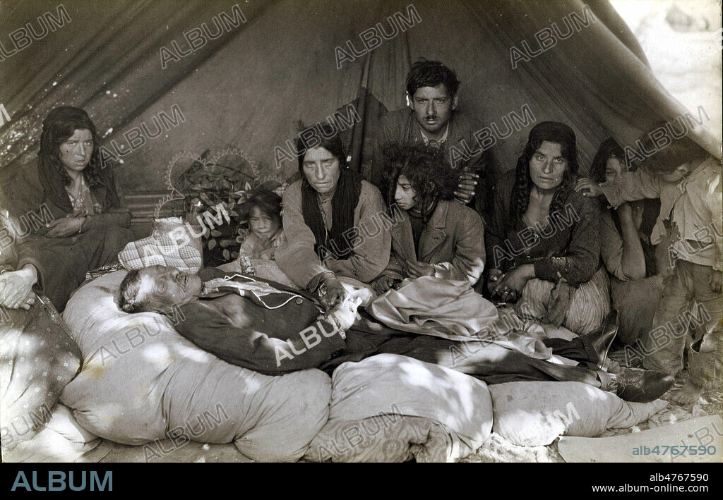Groupe de gitans au chevet d'un vieil homme mourrant. Photographie anonyme pour une carte postale vers 1930. Credit : Collection IM/KHARBINE-TAPABOR.