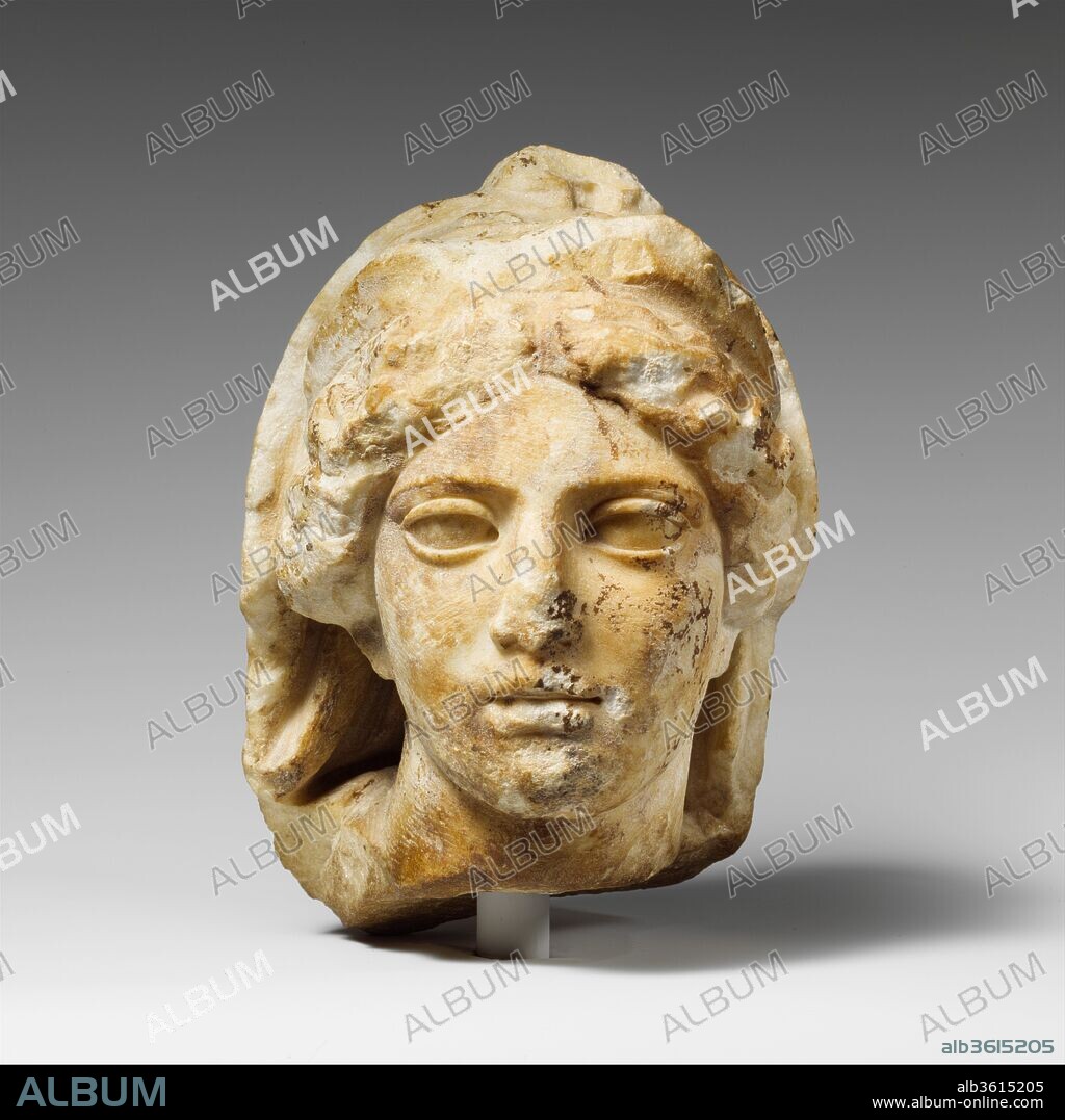 Marble head of a woman wearing diadem and veil. Culture: Greek. Dimensions: H.: 6 7/8 x 5 x 5 3/4 in. (17.5 x 12.7 x 14.6 cm). Date: 425-400 B.C..
The presence of both a diadem and a himation (cloak) drawn over the hair suggests that this small exquisitely carved head represents a female divinity such as Hera or Demeter.  It may have belonged to a figure that was part of a high relief or the pediment of a small building. The strong curve of the neck probably indicates that the goddess was shown as though moving to her left.
