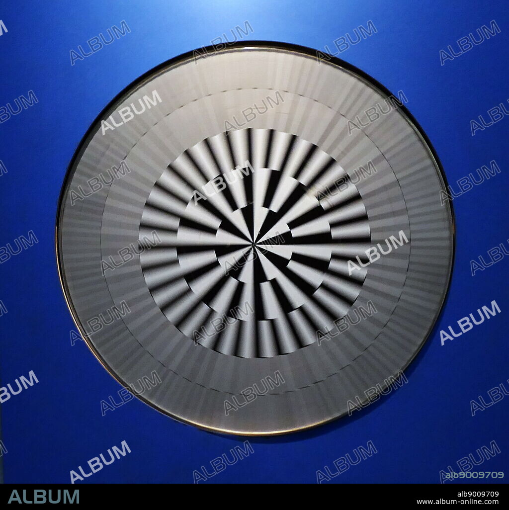 Benham's Disk (Benham's Top) a top painted with the pattern shown. When the disk is spun, arcs of pale colour, called Fechner colours (or pattern-induced flicker colours (PIFCs), are visible at different places on the disk. Not everyone sees the same colours. Created by Charles Benham (1860-1929) an English newspaper-man and toymaker. Dated 19th Century.