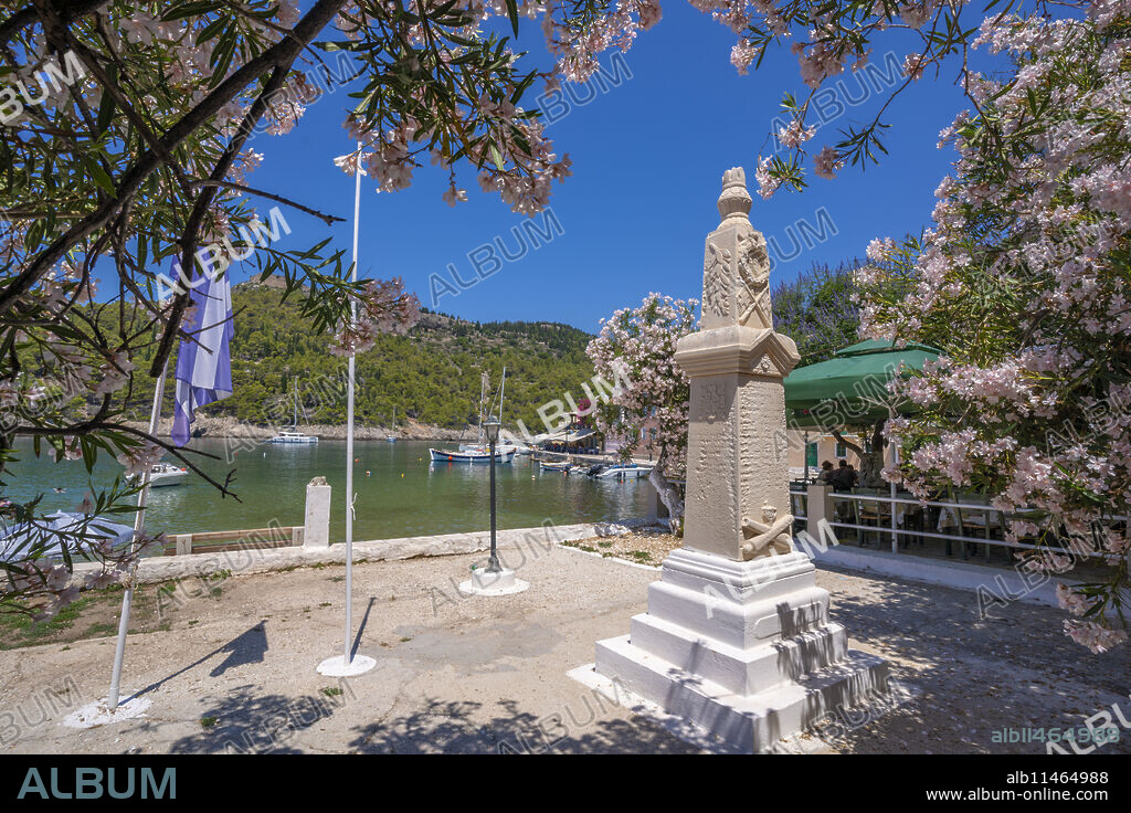 View of statue and colourful houses in Assos, Assos, Kefalonia, Ionian Islands, Greek Islands, Greece, Europe.