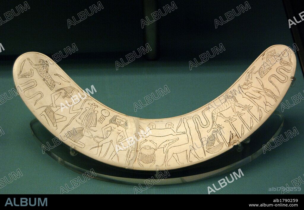 ARTE EGIPCIO. IMPERIO MEDIO. DINASTIA XII. MARFIL MAGICO. Varilla curva y plana de marfil de colmillo de hipopótamo en forma de búmerang e inscrita con deidades y genios protectores para alejar a los espíritus malignos. De uso exclusivamente religioso, servía de talismán que ofrecía protección mágica a mujeres y niños. Procede de Tebas. Museo Británico. Londres. Inglaterra. Reino Unido.