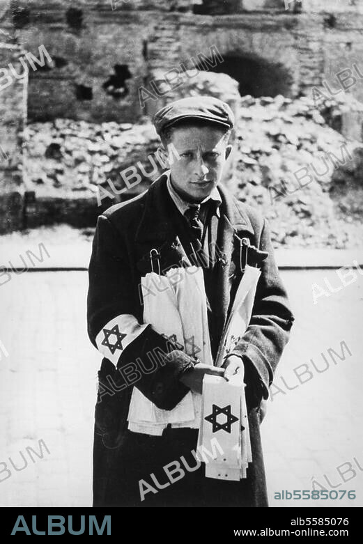 World War II / Warsaw Ghetto. (created in 1940 during the German occupation for the ghettoisation and deportation of the Jewish population; destroyed in 1943 after revolt). Young boy in the Warsaw Ghetto, selling armbands with the Star of David. Photo (E. Gnilka), 1940.