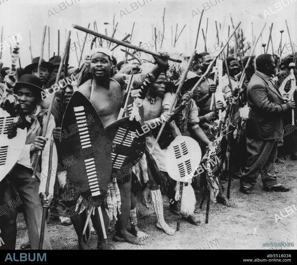 Zulus Honor Nation's Founder -- Zulu tribesmen, some in native dress, others in civilian clothing and still others, in a mixture of each, chant and dance during ceremonies honoring Tahaka, founder of the Zulus, at Stanger, Natal, Africa, recently. A marble monument in honor of Tahaka  was unveiled during the ceremonies, PS: Dig the derby and porkpie hats at left. October 03, 1954. (Photo by AP Wirephoto).