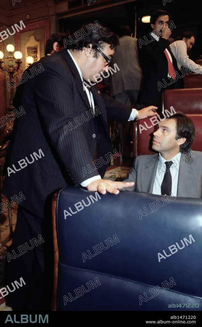 PECES BARBA, Gregorio. Político español. Miembro destacado del PSOE. Presidente del Congreso de los Diputados durante el primer gobierno de Felipe González (octubre de 1982). Peces Barba departiendo con FELIPE GONZALEZ en la celebración de un pleno en el Congreso de los Diputados, formando parte de la oposición al gobierno Suárez.