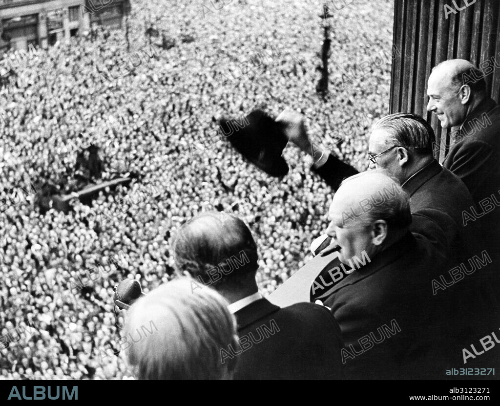 Photograph of Sir Winston Churchill (1874-1965) British statesman who was the Prime Minister of the United Kingdom, looking out over crowds celebrating the end of the Second World War in London. Dated 1945.