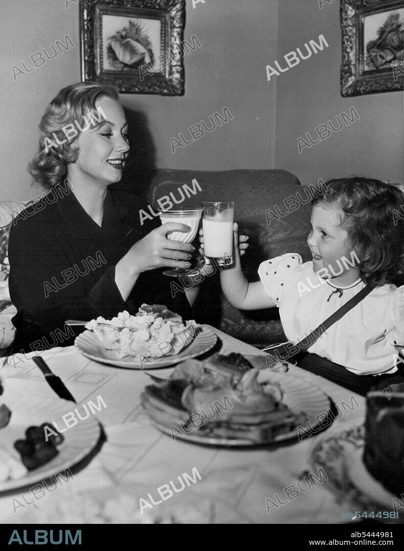 Mother And Daughter. . . Ann Sothern and her small daughter Tish enjoy luncheon together in Miss Sothern's dressing room during work on Metro-Goldwyn-Mayer's exciting mystery thriller, "Death in the Doll's House." The cast of the film is headed by Miss Sothern, Zachary Scott, Gigi Perreau, Kristine Miller, Nancy Davis and John McIntire. It was directed by Patrick Jackson and produced by Robert Sisk. Cheers! (Milk Variety) -- Ann Sothern and her small daughter toast one another in milk during luncheon in Ann's dressing room during work on MGM's mystery thriller, Death in the Doll's House. October 10, 1949.